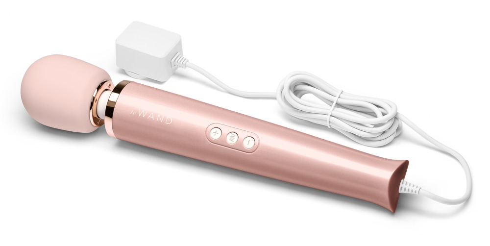 Ein roségoldener Stabvibrator mit weißem Kopf, Bedienelementen und einem angeschlossenen weißen Ladekabel auf weißem Hintergrund.