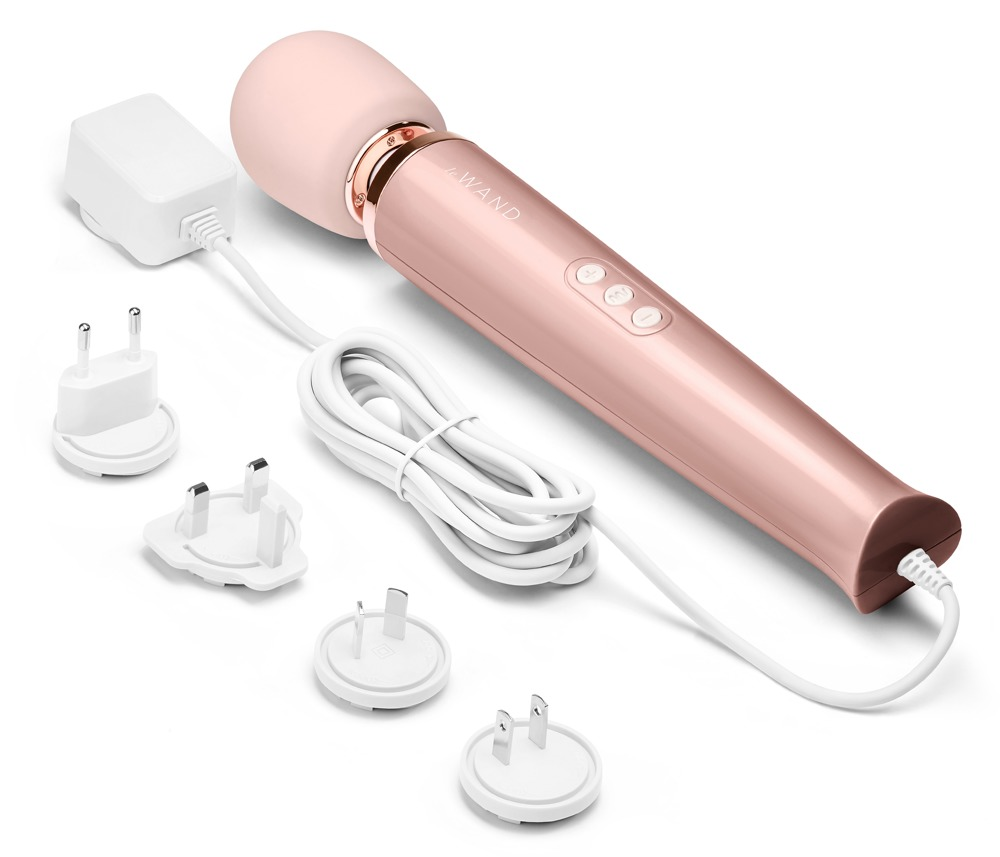 Ein roségoldener Magic Wand Massagestab mit weißem Netzkabel und vier verschiedenen internationalen Steckdosenadaptern.
