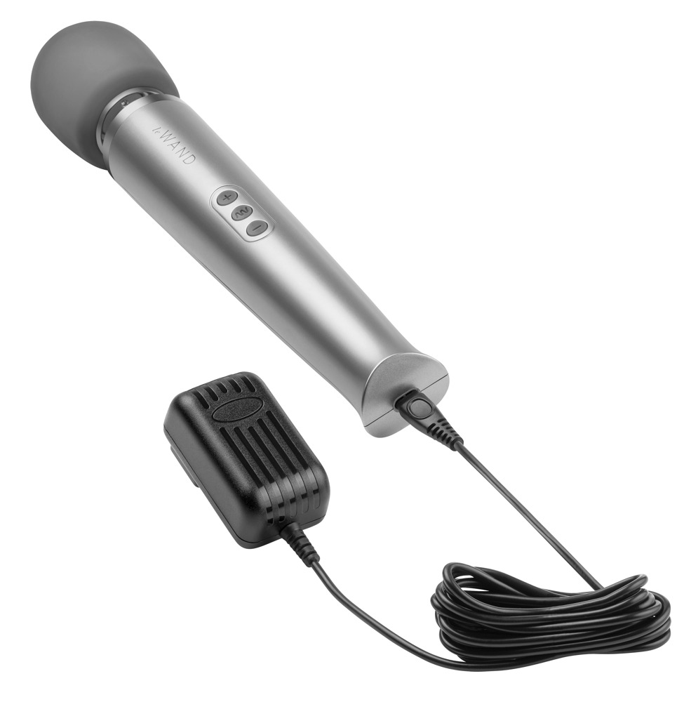 Ein silberner Zauberstab-Vibrator mit grauem Kopf, Bedienelementen und einem angeschlossenen schwarzen Ladekabel auf weißem Hintergrund.