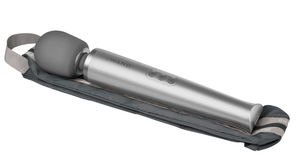 Ein silberner Lelo Wand Massager liegt auf einem passenden grauen Stoffbeutel vor weißem Hintergrund.