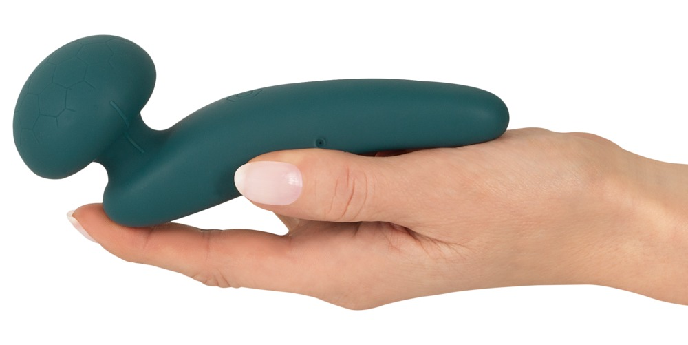 Eine Hand hält ein mattgrünes, ergonomisches Wellness-Gerät mit sechseckiger Musterung.