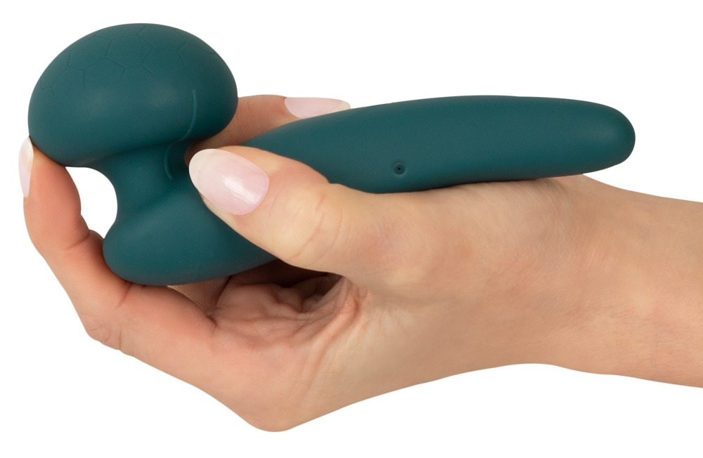 Eine Hand hält einen dunkelgrünen, ergonomischen Silikonvibrator vor weißem Hintergrund.