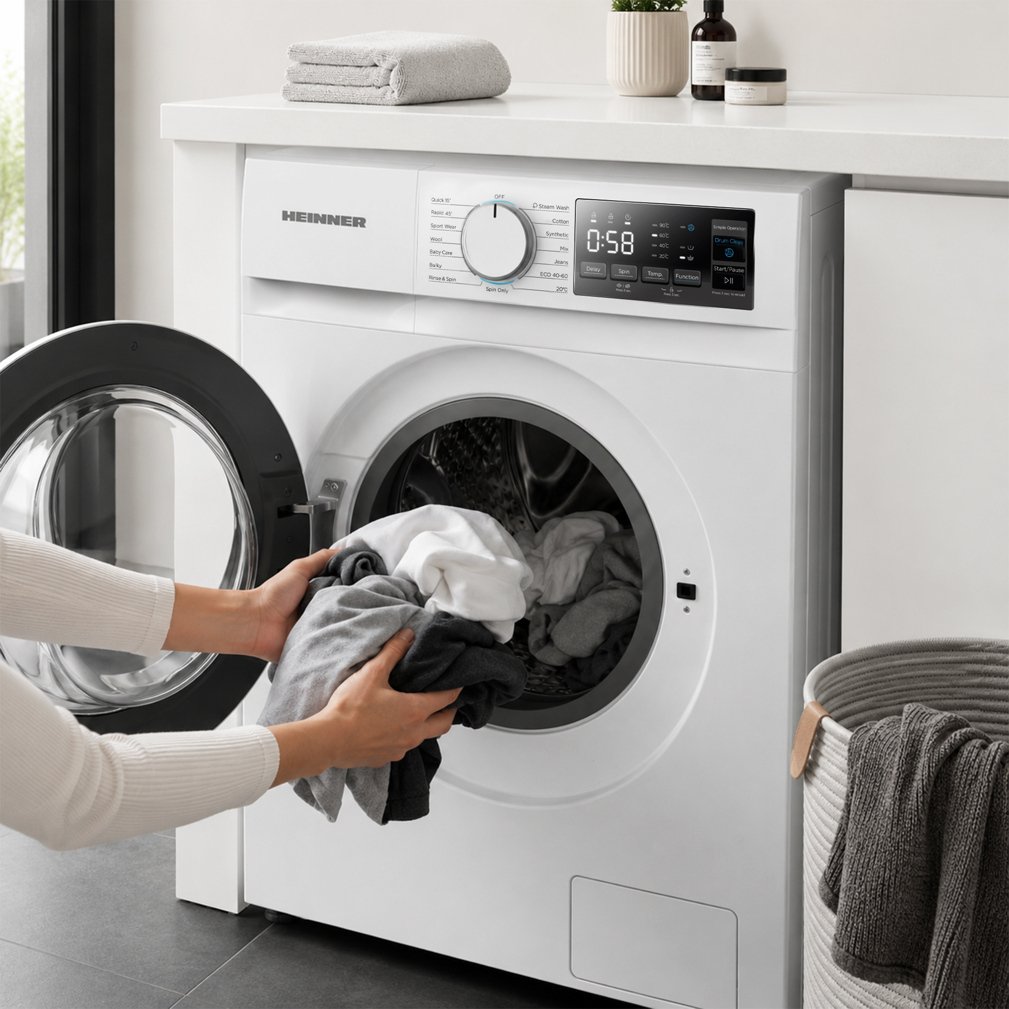 Une personne charge du linge dans le tambour ouvert d'un lave-linge blanc.