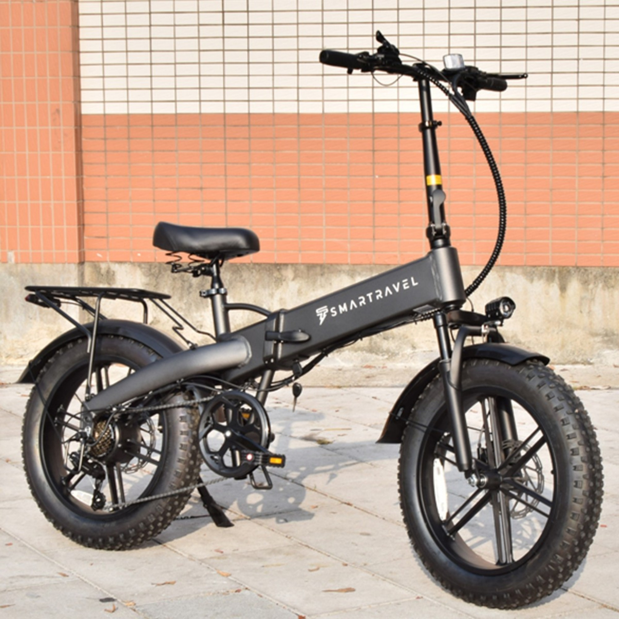 Czarny elektryczny rower składany Smartravel z grubymi oponami, zaparkowany na zewnątrz.