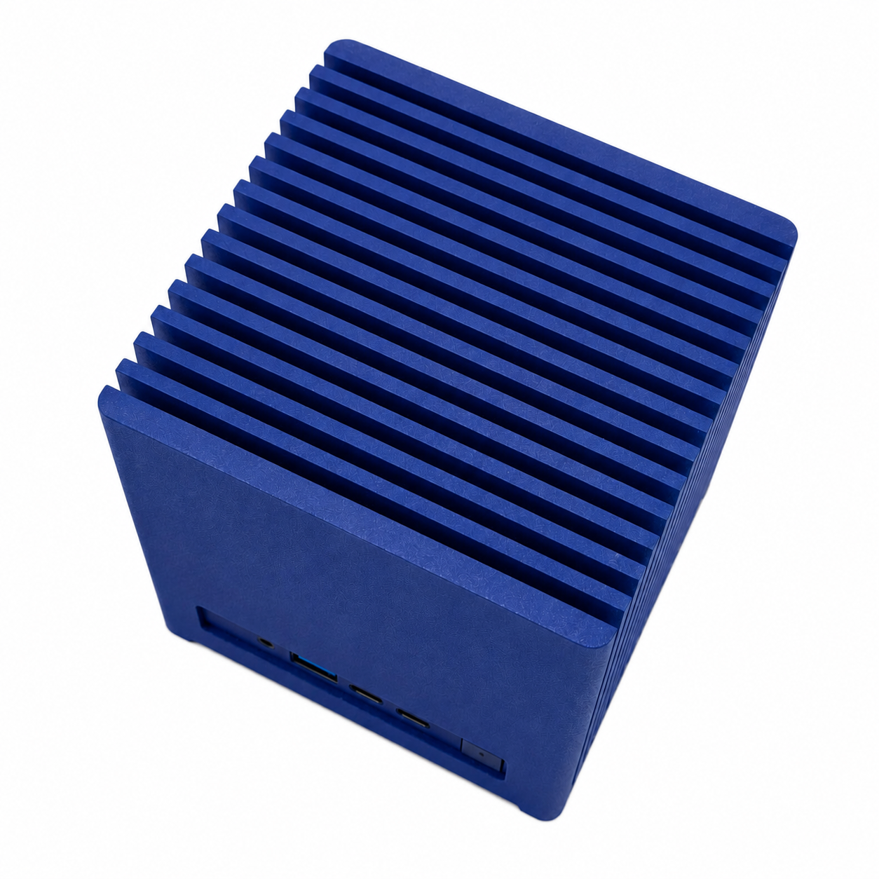Un mini PC blu a forma di cubo con superficie scanalata e porte anteriori su sfondo bianco.