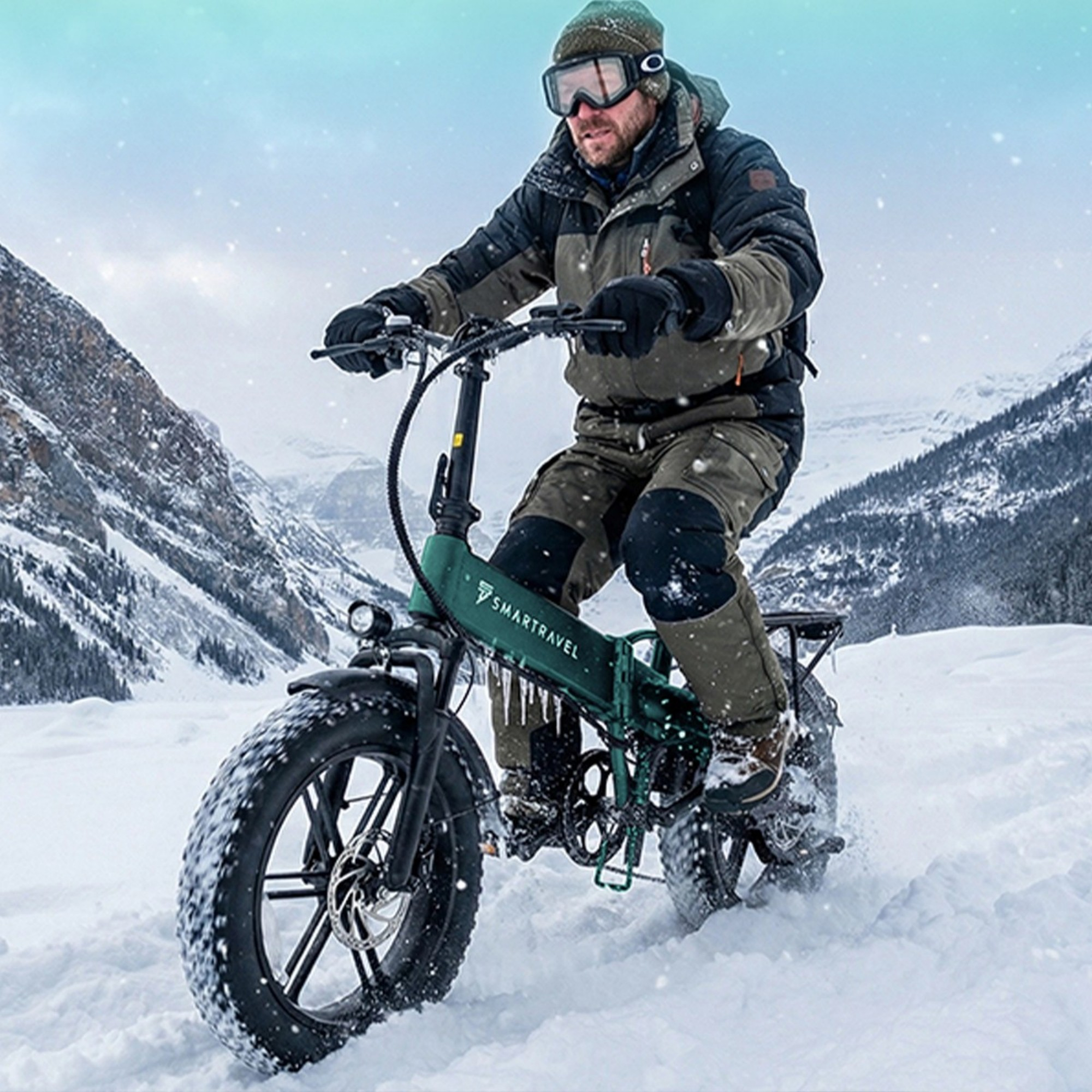 Mężczyzna w goglach narciarskich jedzie na zielonym rowerze fatbike przez zaśnieżone góry.