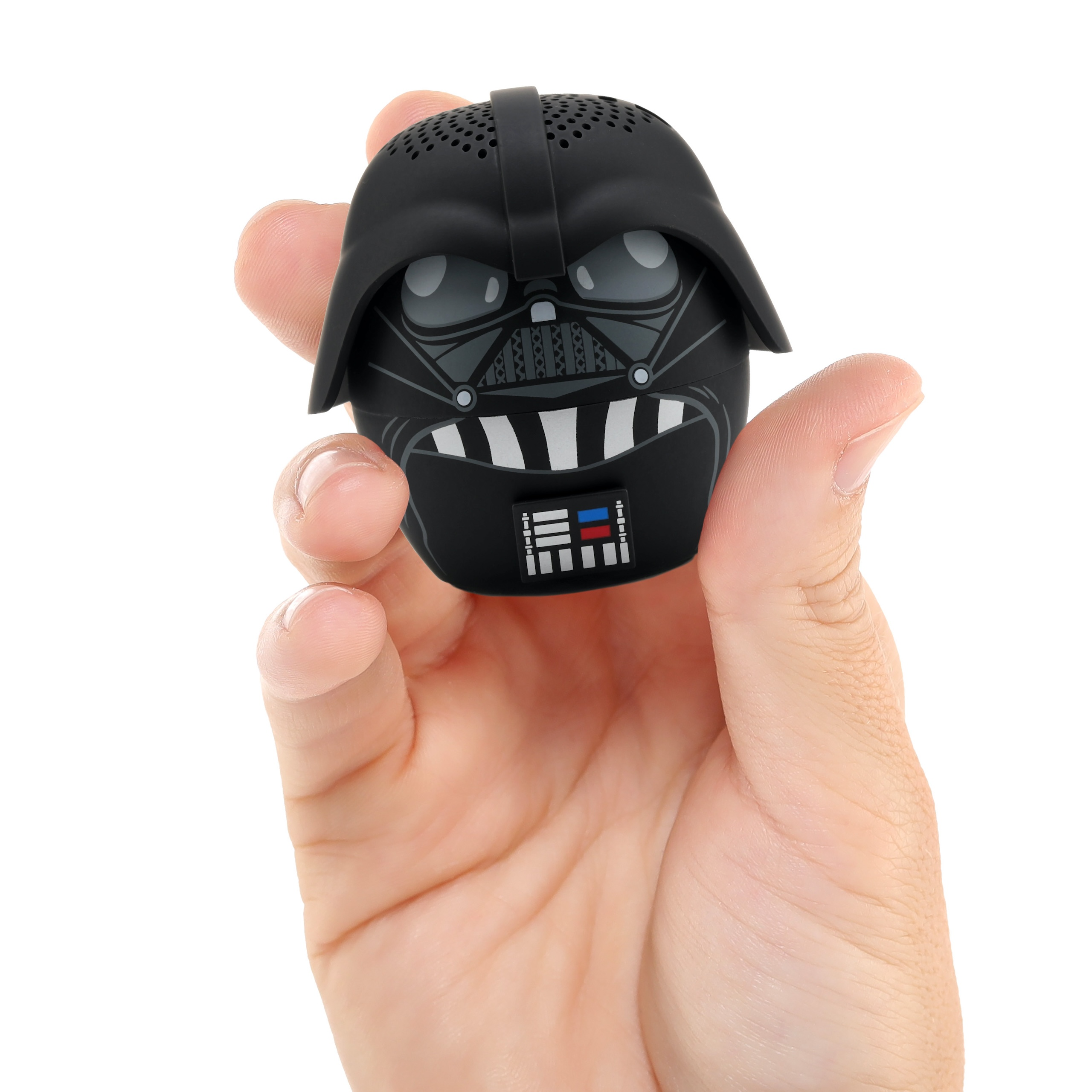 Dłoń trzyma mały czarny głośnik Bluetooth w kształcie hełmu Dartha Vadera na białym tle.