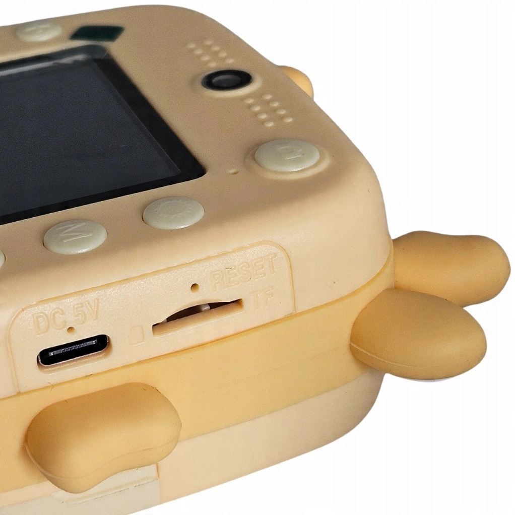 Primo piano di una fotocamera digitale beige per bambini con porta USB-C, slot micro SD e tasti.