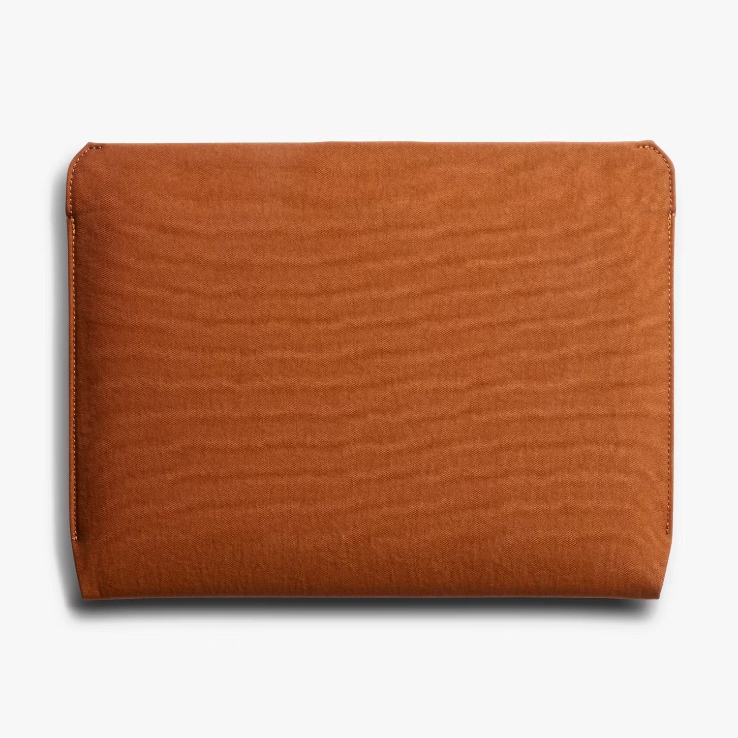 Brązowe materiałowe etui na laptopa leży na białym tle.