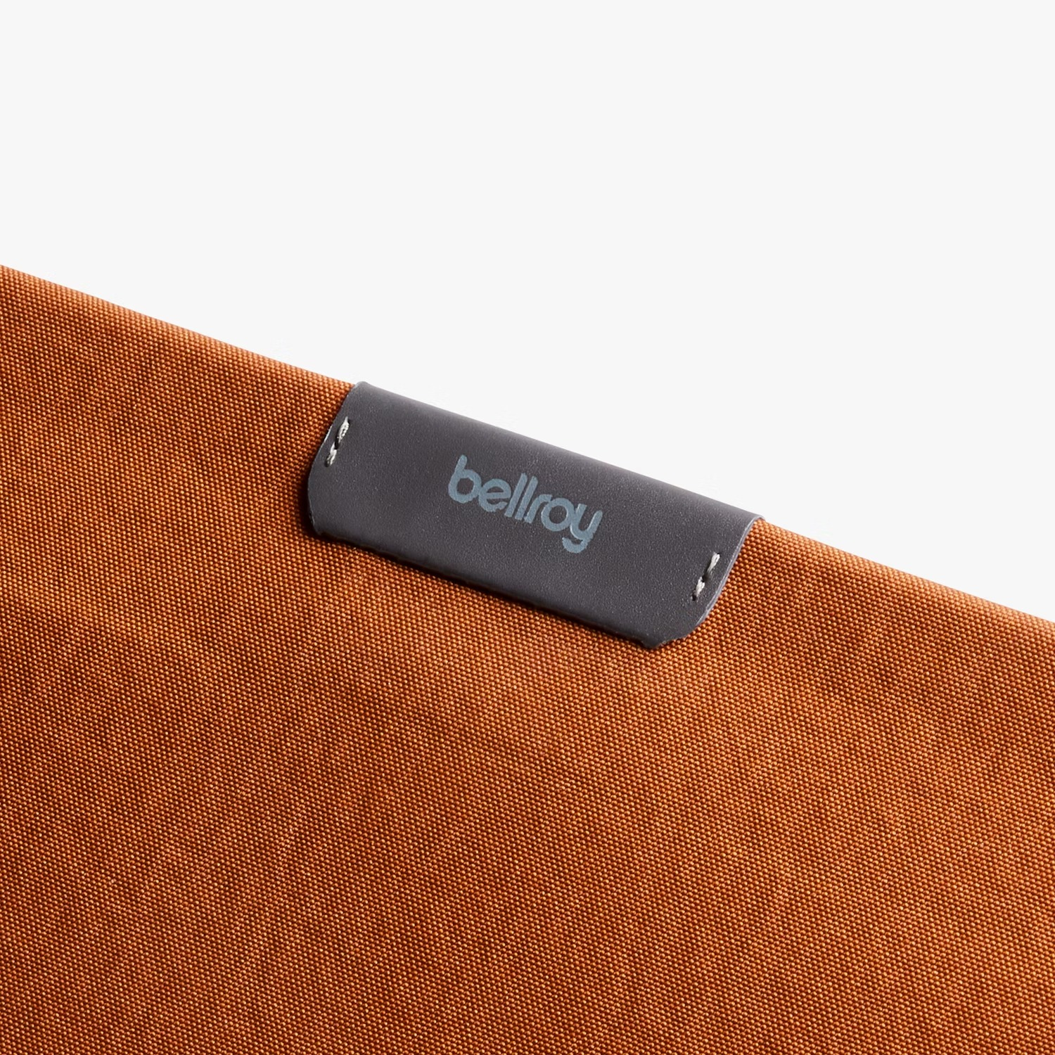 Brązowa torba z tkaniny z szarą skórzaną etykietą i logo Bellroy.