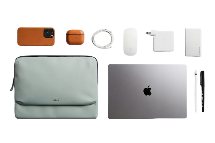 Płaski układ akcesoriów technologicznych, w tym laptop, etui, telefon, słuchawki, ładowarka, kabel, mysz i długopisy.