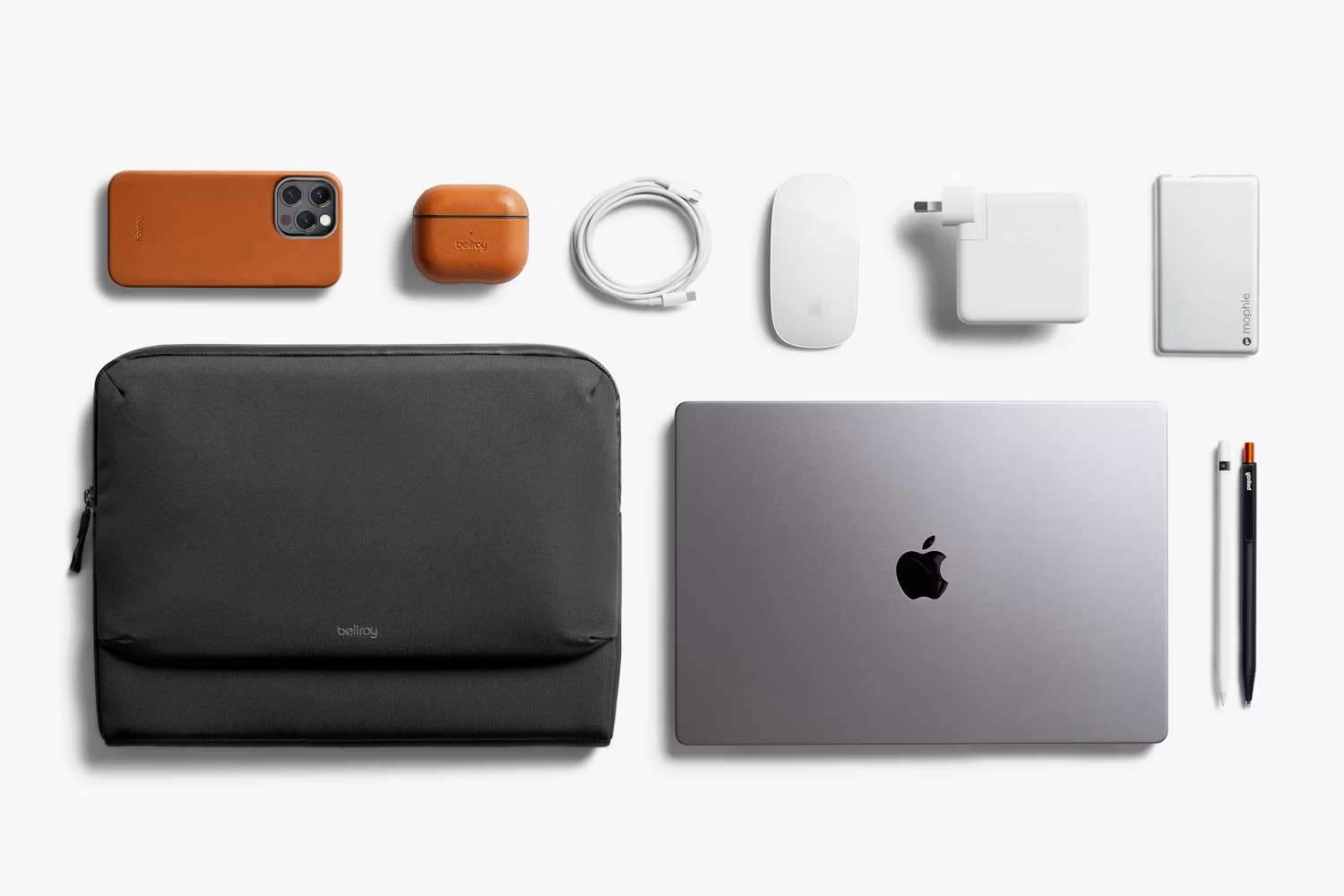Uporządkowany układ akcesoriów technologicznych na białym tle, w tym laptop, etui, telefon, mysz, ładowarka i długopisy.