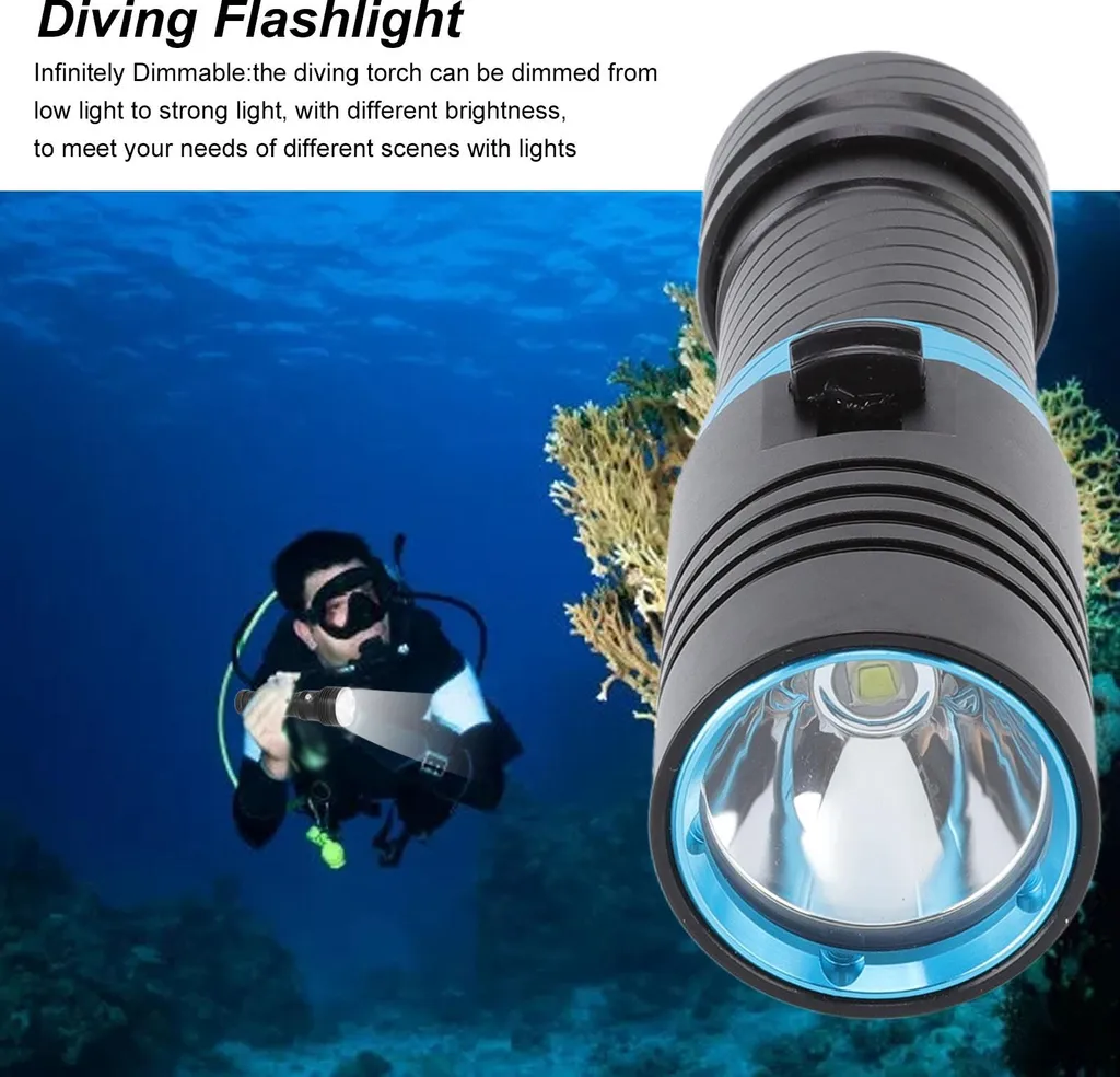 Schwarze und blaue Taucherlampe im Vordergrund, dahinter ein Taucher unter Wasser mit Korallen.