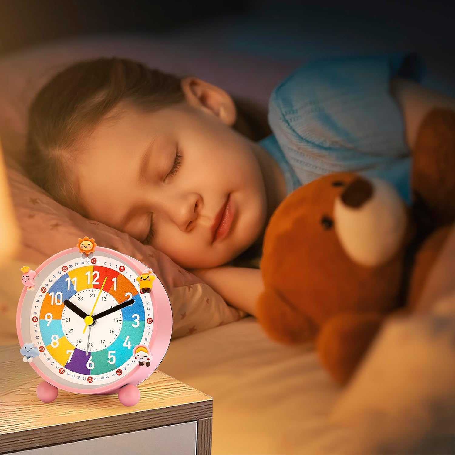 Ein Kind schläft friedlich im Bett mit einem Teddybären, während auf dem Nachttisch eine bunte Kinderweckuhr steht.