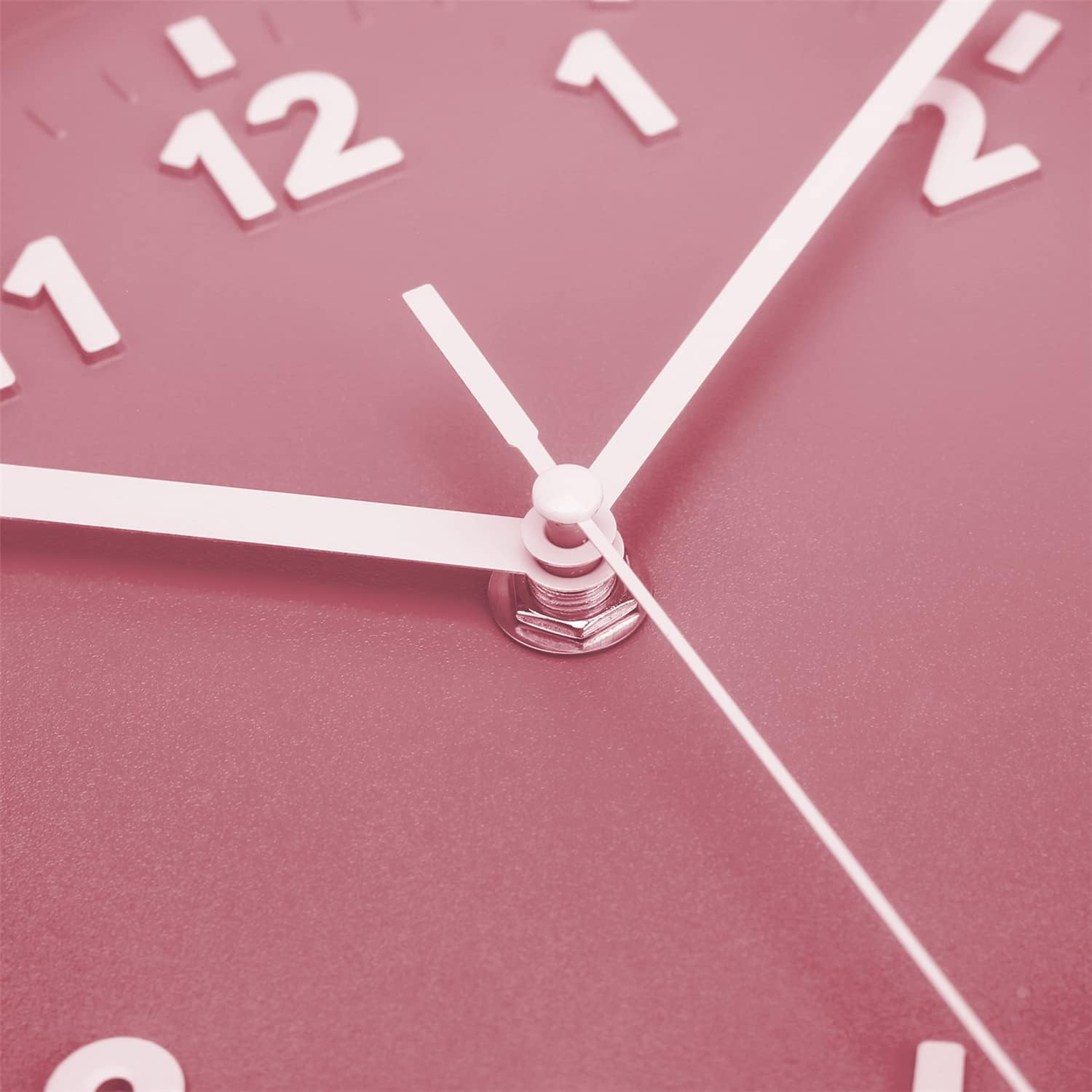 Nahaufnahme eines rosa Wandzifferblatts mit weißen Zahlen und Zeigern nahe 11 und 2.