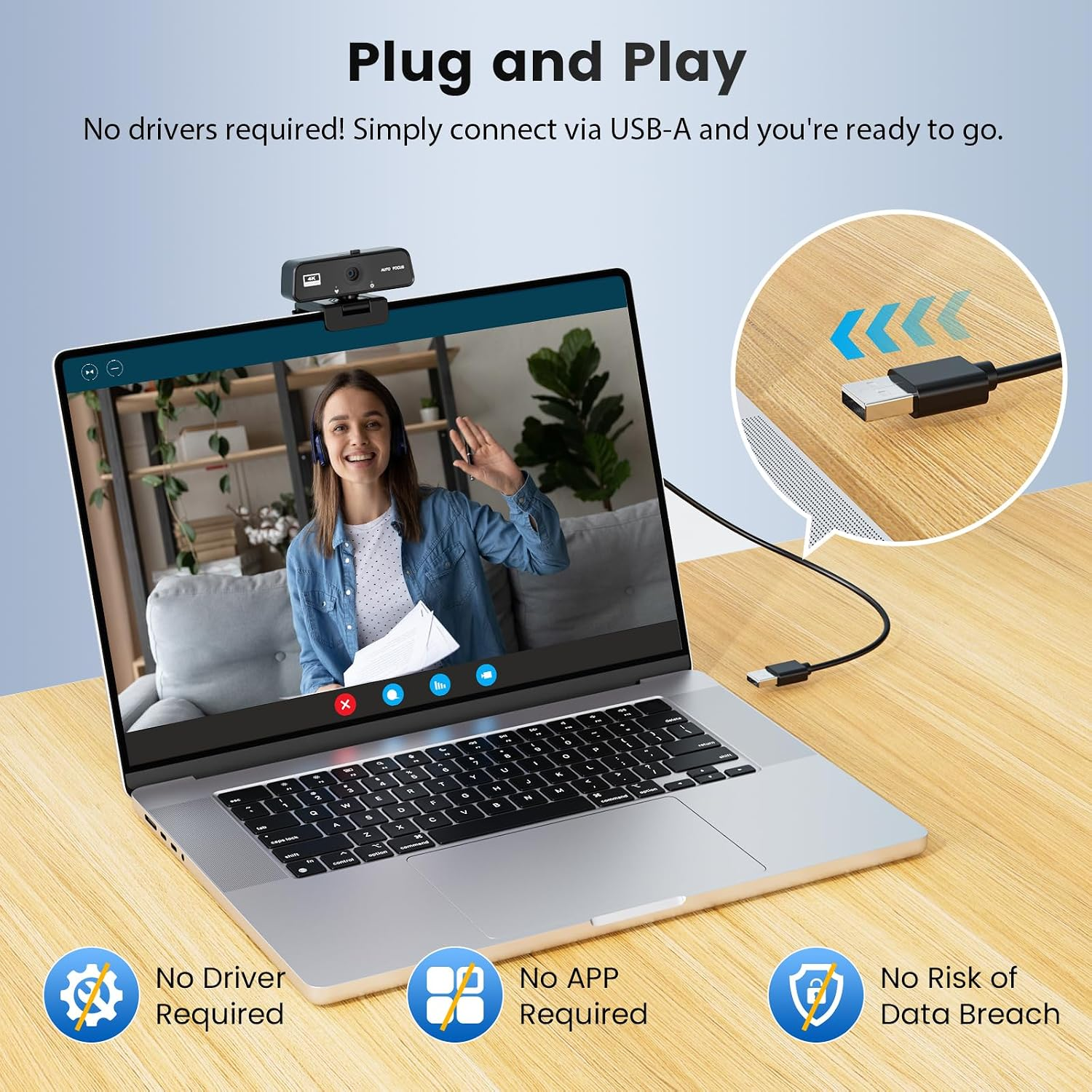 Laptop mit Webcam auf Holztisch zeigt Frau im Videocall. USB-Kabel wird eingesteckt.