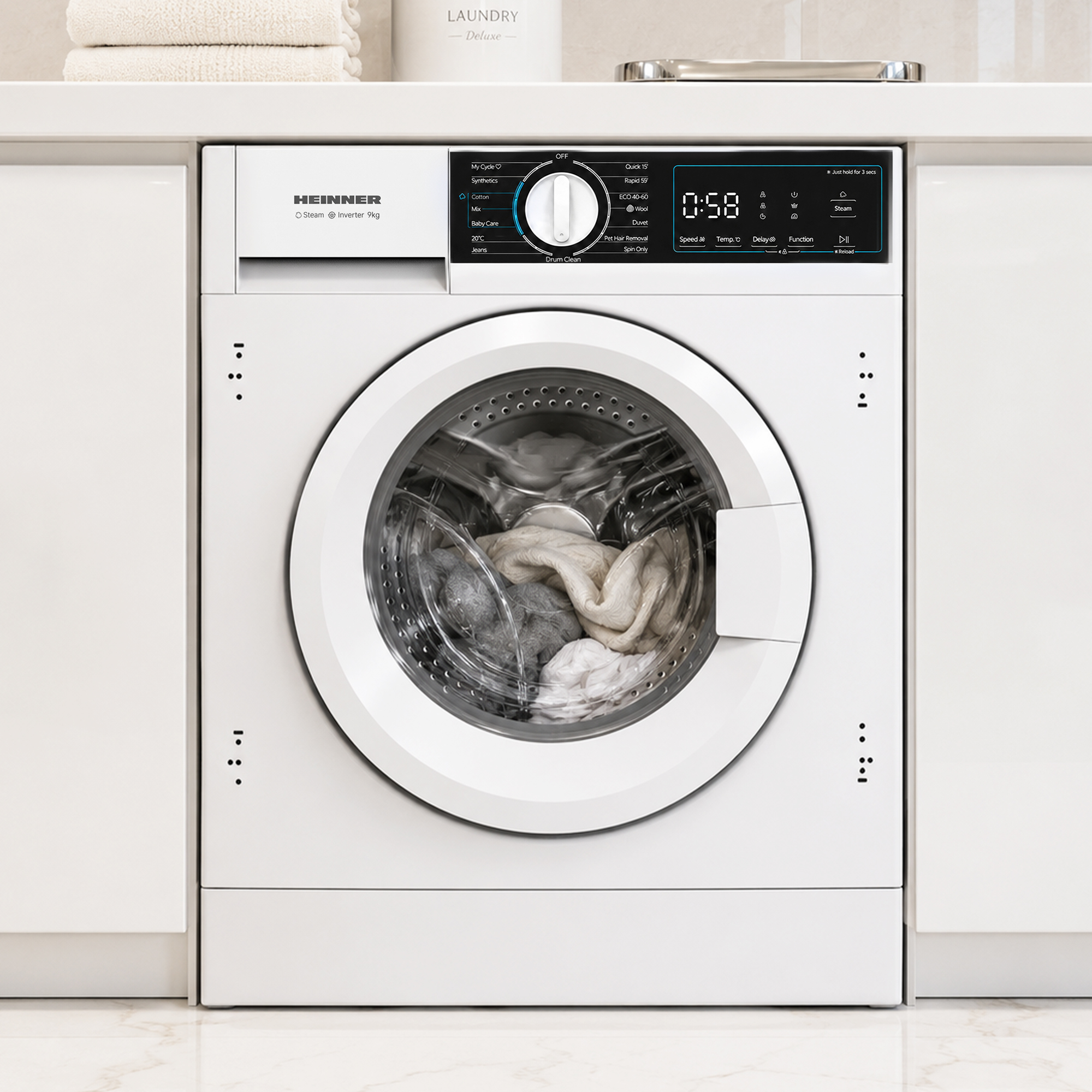 Un lave-linge blanc Heinner avec écran numérique et du linge dans le tambour.
