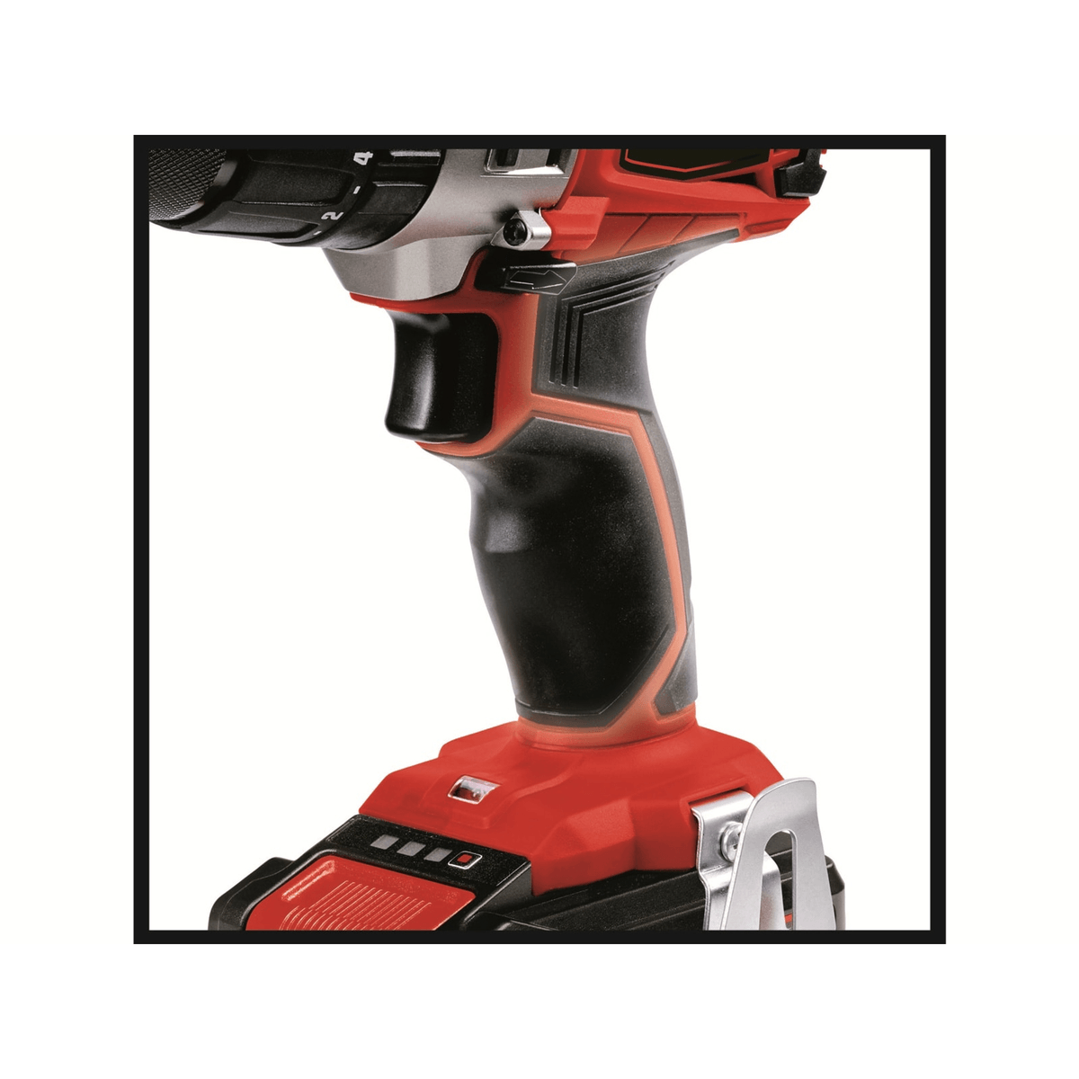 Primer plano del mango ergonómico negro y rojo de un taladro inalámbrico, con batería y clip para cinturón.