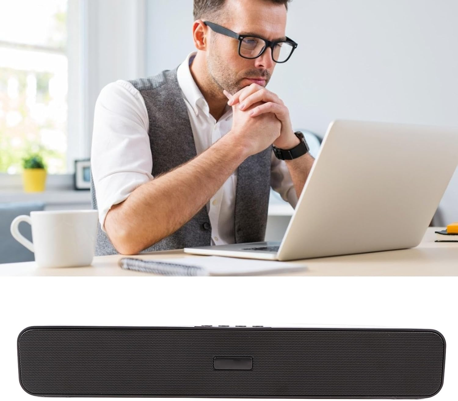 Ein Mann mit Brille schaut nachdenklich auf einen Laptop, mit einer weißen Tasse auf dem Tisch.