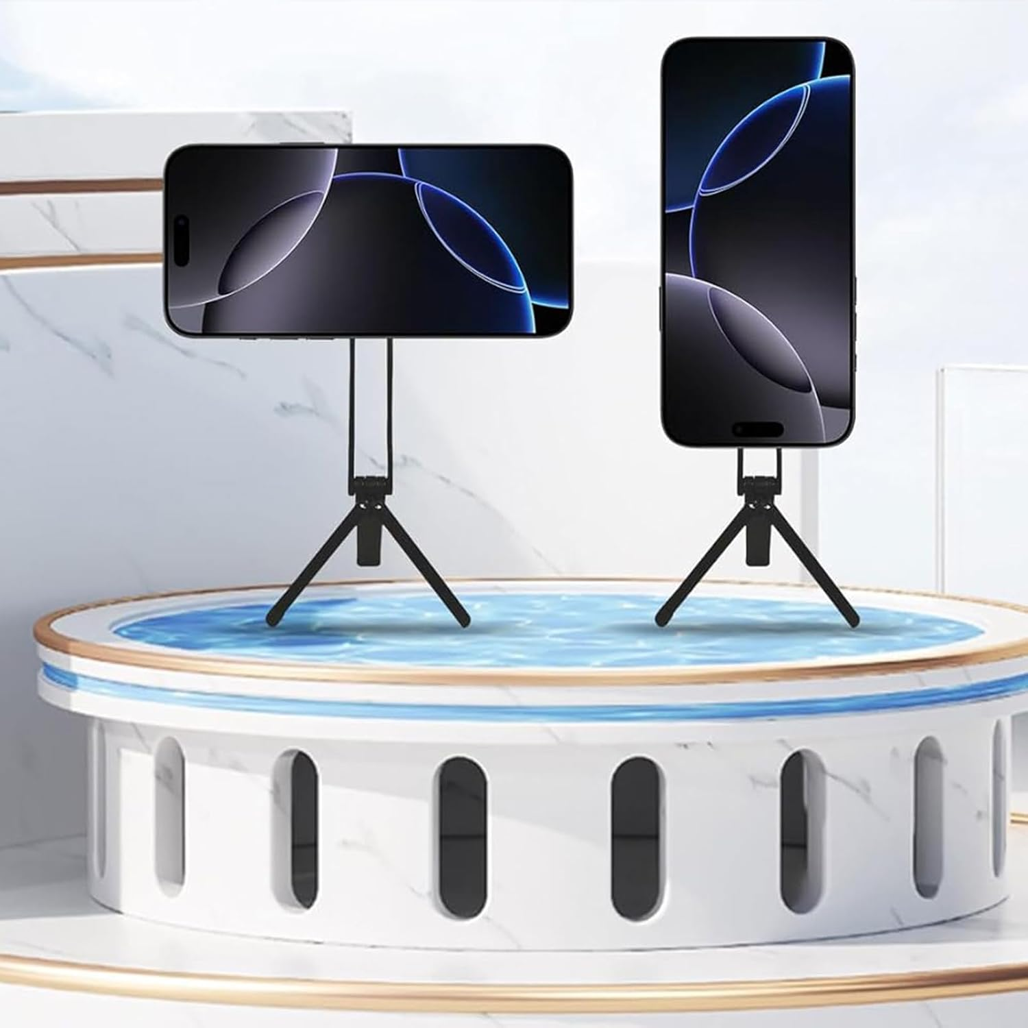 Zwei Smartphones auf schwarzen Stativen stehen auf einer weiß-goldenen runden Plattform mit blauem Wassermotiv.