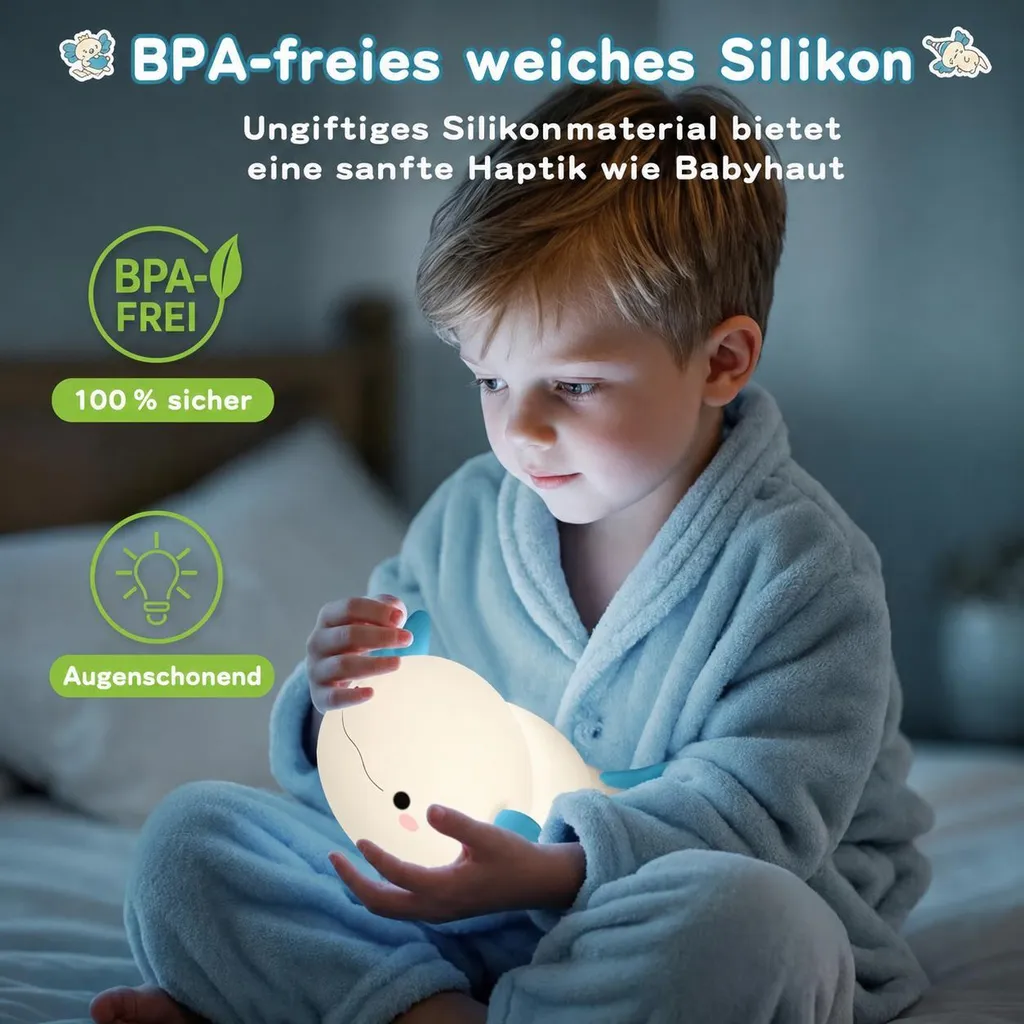 Ein Junge im blauen Pyjama hält in einem schwach beleuchteten Zimmer ein leuchtendes Wal-Nachtlicht.