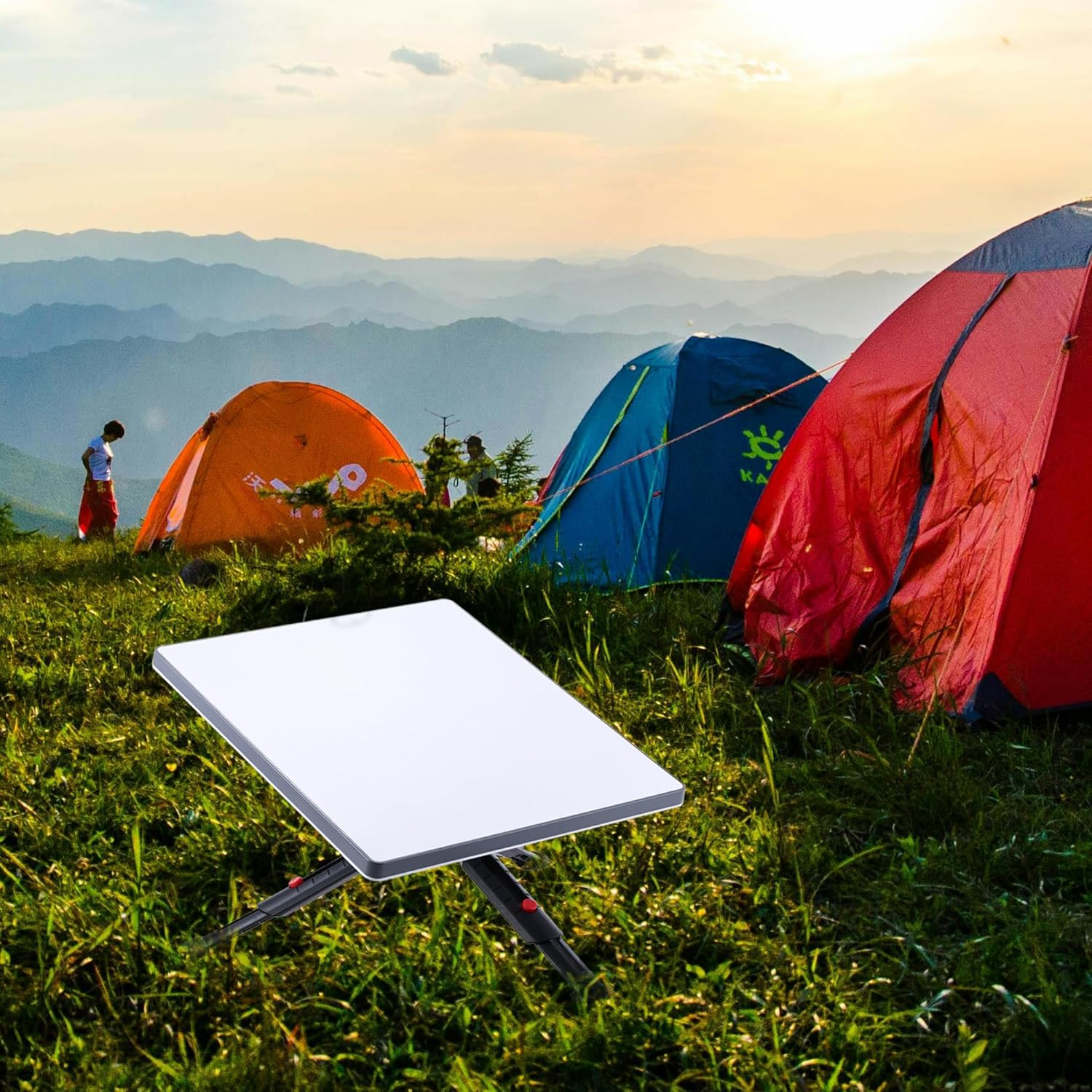 Eine Satellitenschüssel steht auf einer Wiese im Vordergrund, dahinter bunte Zelte und bergige Landschaft bei Sonnenuntergang.