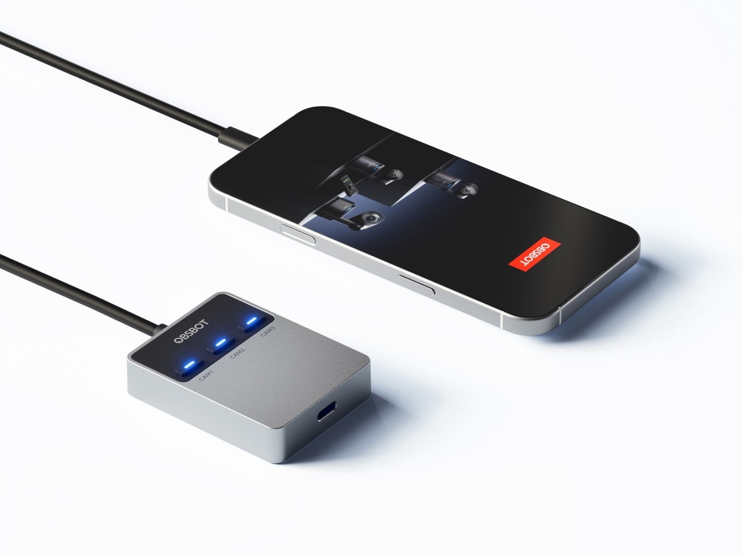 Un controller Obsbot argento con LED blu e uno smartphone con un'app fotocamera su sfondo bianco.