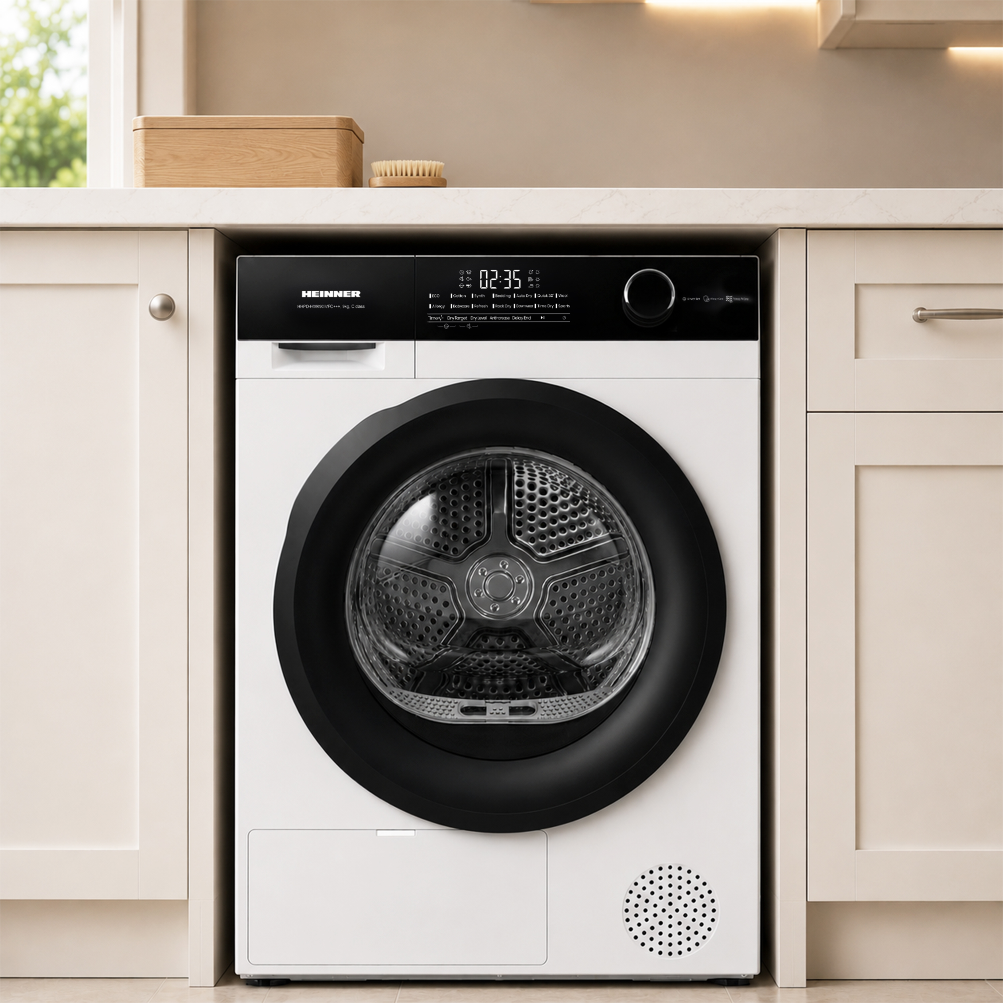 A white Heinner tumble dryer with a black control panel sits under a kitchen counter.