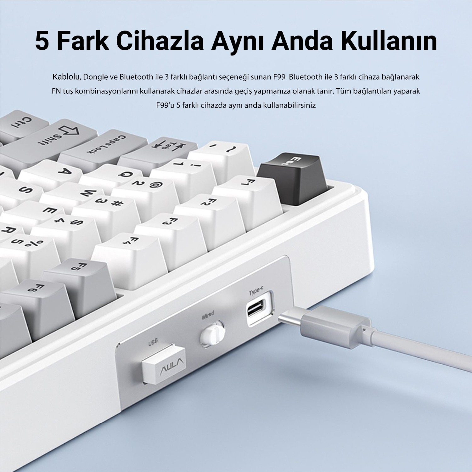 Açık mavi arka planda Type-C bağlantı noktası, USB dongle ve anahtar bulunan beyaz klavye.