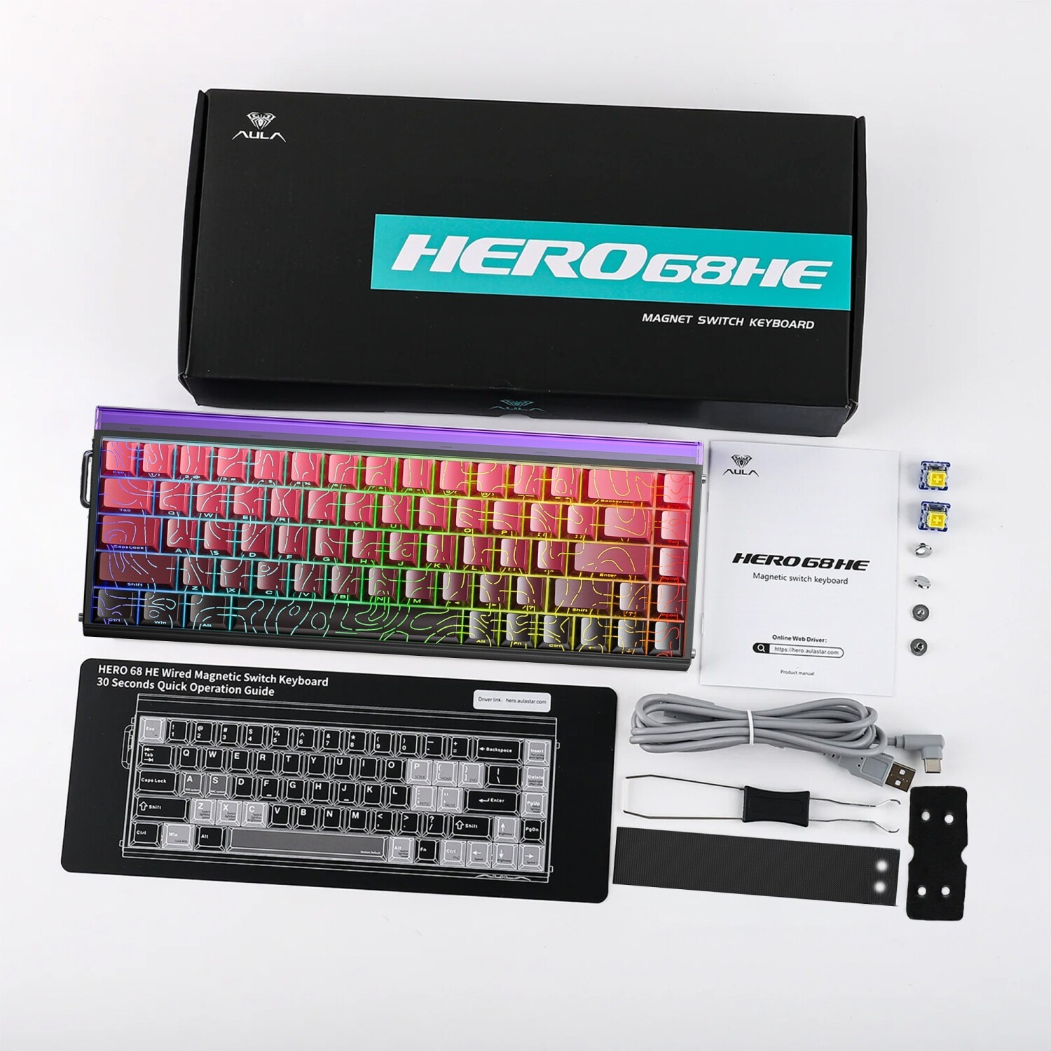 Kutu, kırmızı desenli klavye, kılavuz, kablo, switch ve aletleri içeren beyaz zeminli HERO68HE klavye seti.
