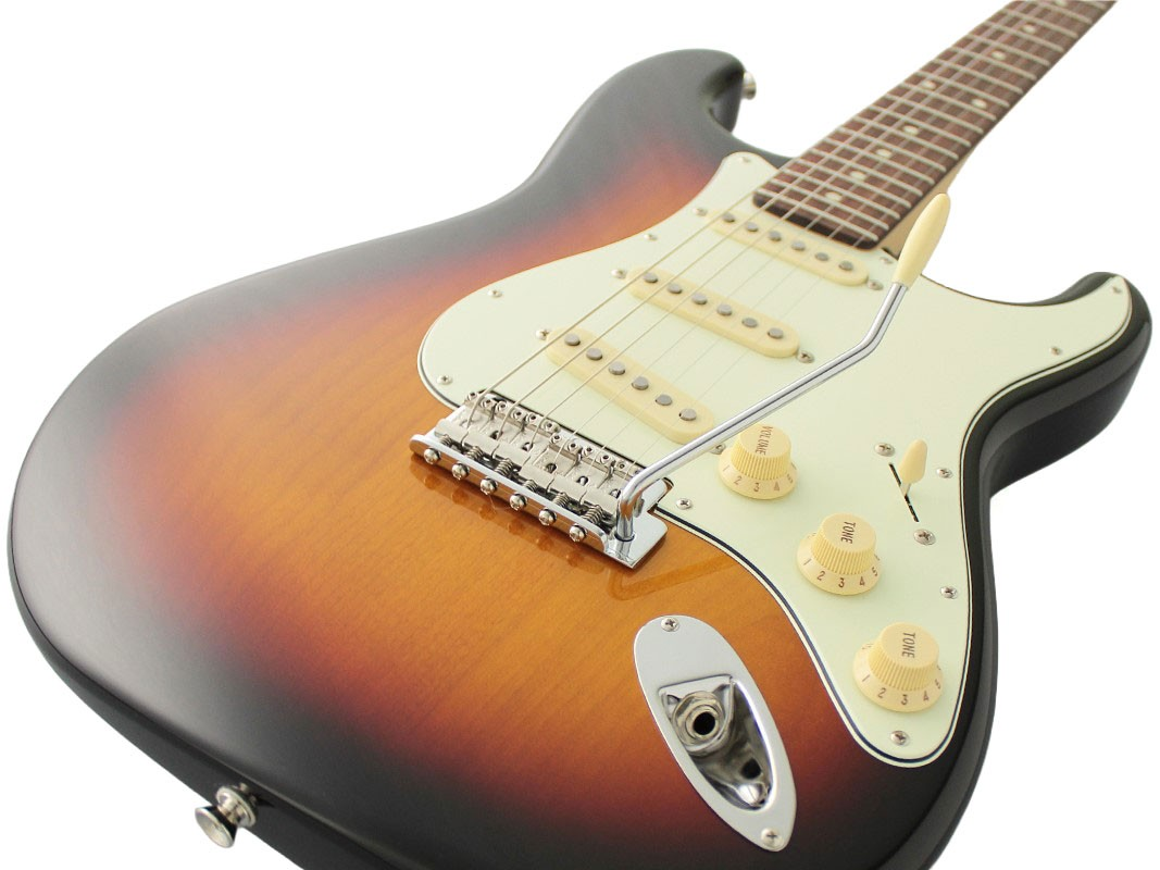 Beyaz bir pena koruması, mıknatıslar ve düğmelerle donatılmış güneş rengi elektro gitar.