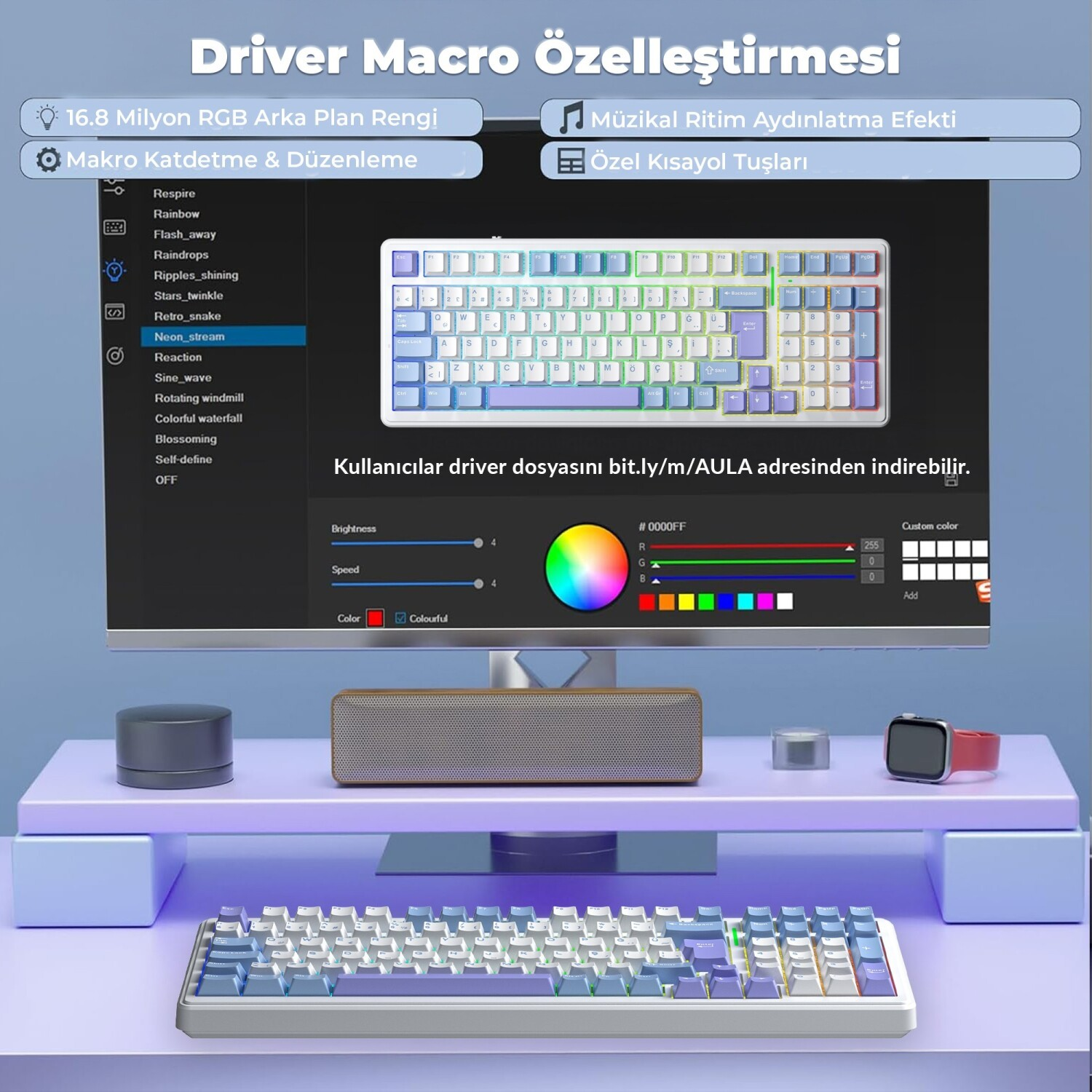 Bilgisayar monitöründe klavye yazılımı, ön masada hoparlör ve klavye var.