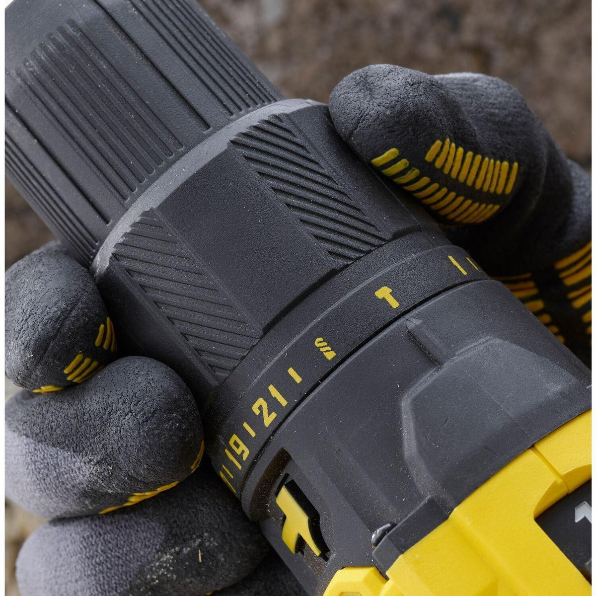 Primer plano de un taladro eléctrico negro y amarillo sostenido por una mano enguantada.