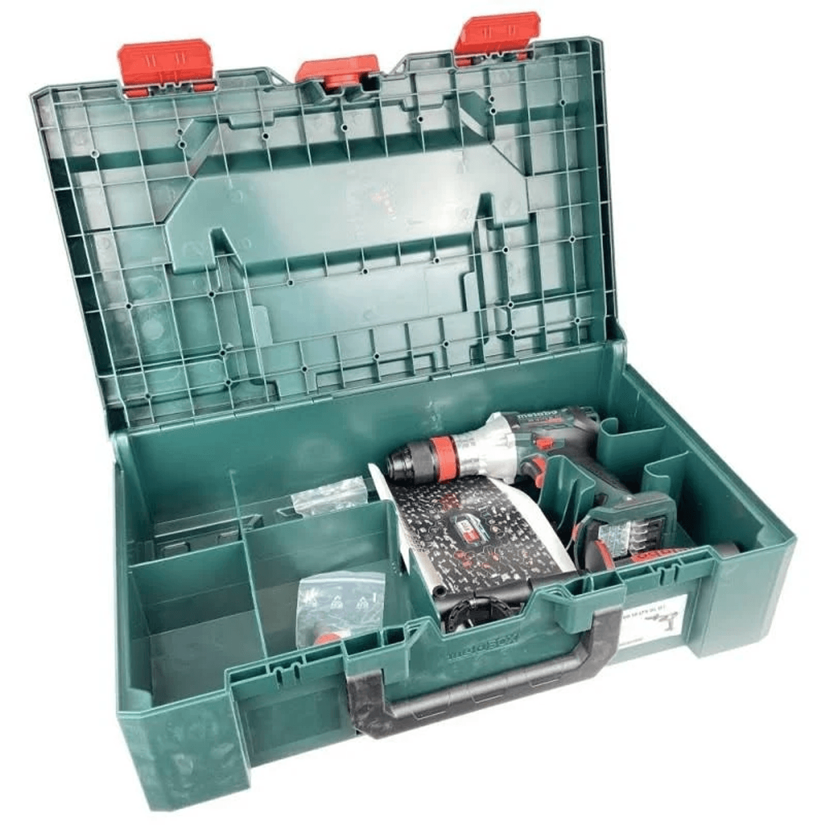 Caja de herramientas verde abierta con cierres rojos que contiene un taladro y accesorios.