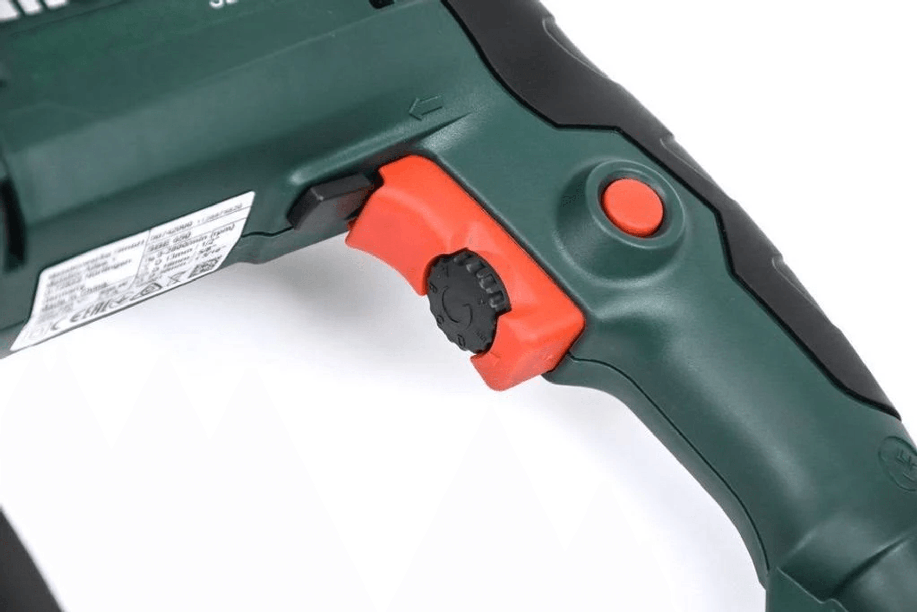 Primer plano del mango de la herramienta eléctrica verde y negra con gatillo rojo y selector de velocidad.