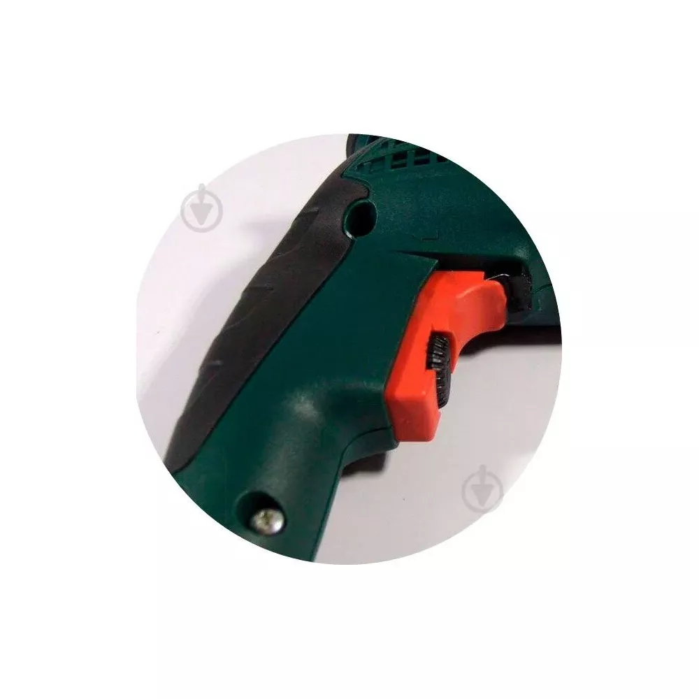 Primer plano del gatillo rojo y el mango de un taladro verde y negro.