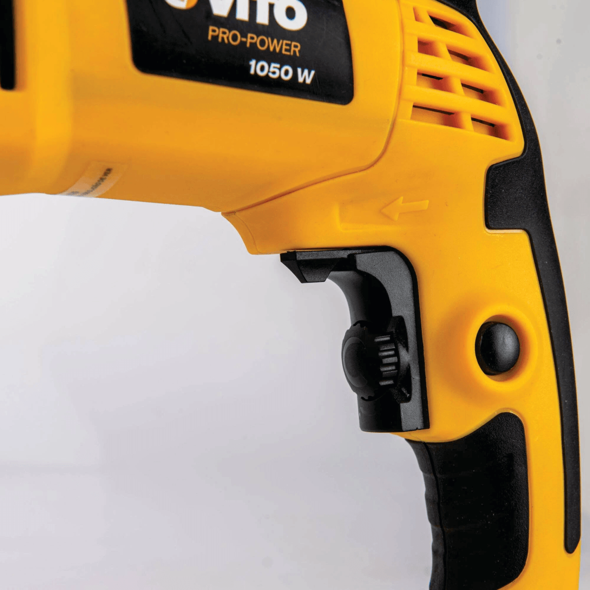 Primer plano del taladro eléctrico amarillo y negro, centrándose en el gatillo y el regulador.