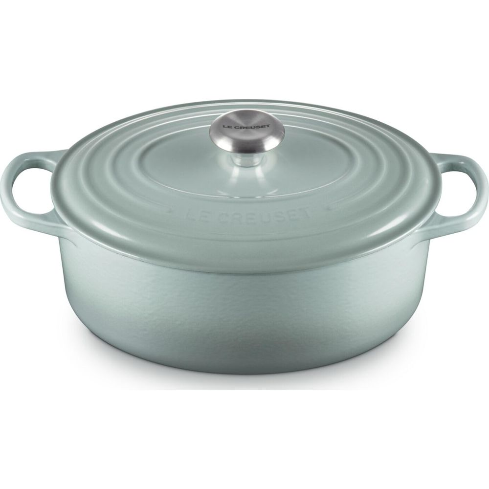 Una casseruola tonda in ghisa azzurra Le Creuset con pomello argentato su sfondo bianco.