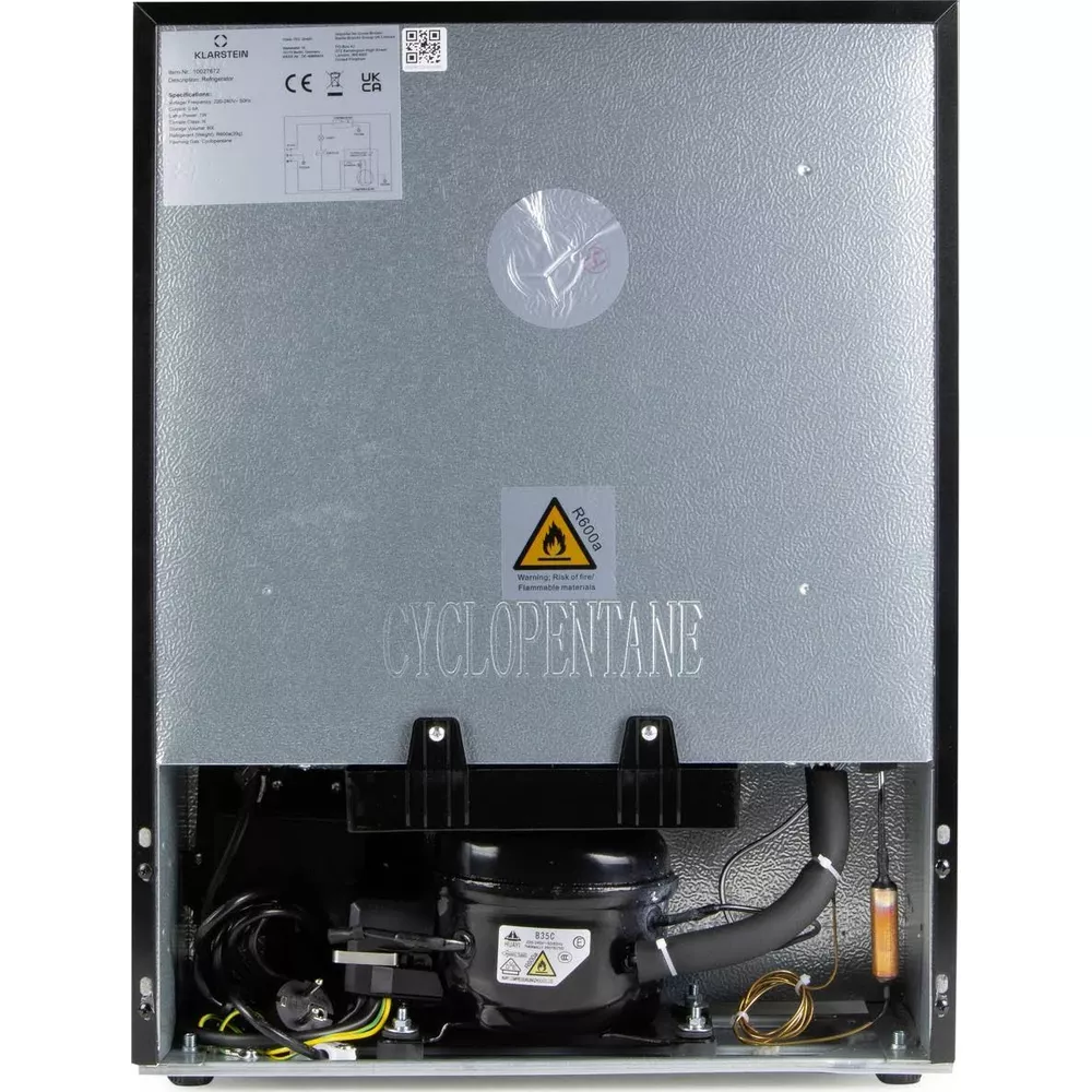 Retro di un apparecchio nero con compressore, cavi, pannello in metallo argentato, etichette di avvertenza e logo.