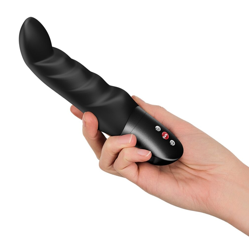 Eine Hand hält ein schwarzes, gewelltes Wellness-Gerät mit silbernen Knöpfen.