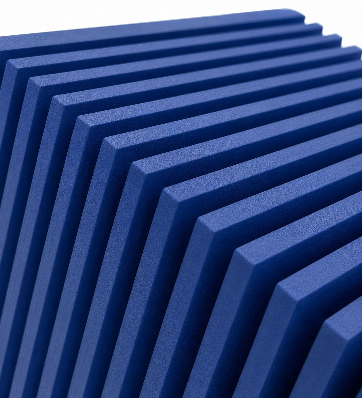 Blaue gerippte Akustikpaneele in einem geometrischen Winkel auf weißem Hintergrund.