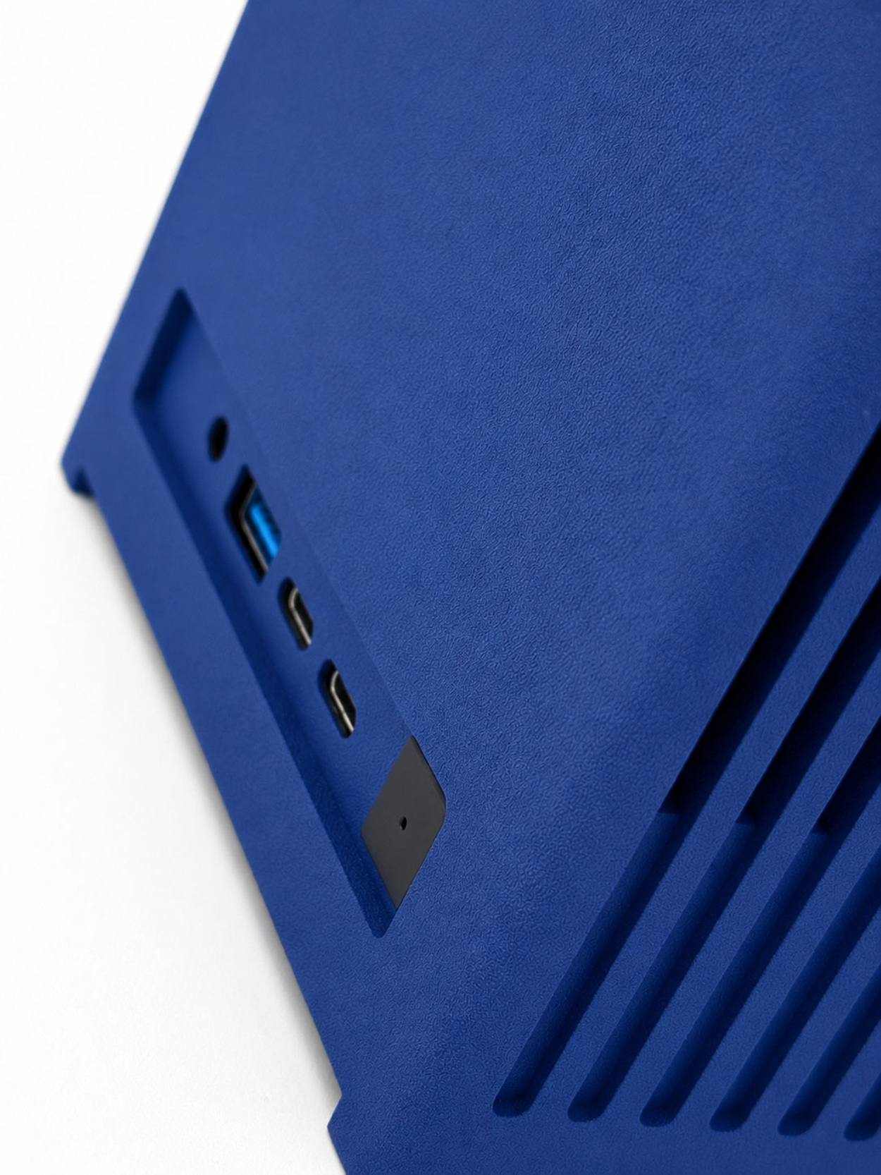 Console blu con jack audio, porte USB e feritoie di ventilazione su sfondo bianco.