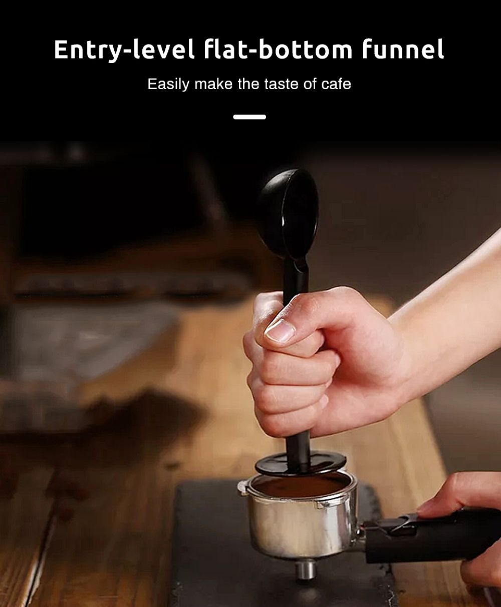 Una mano preme un pressino per caffè in un portafiltro su un tavolo di legno.
