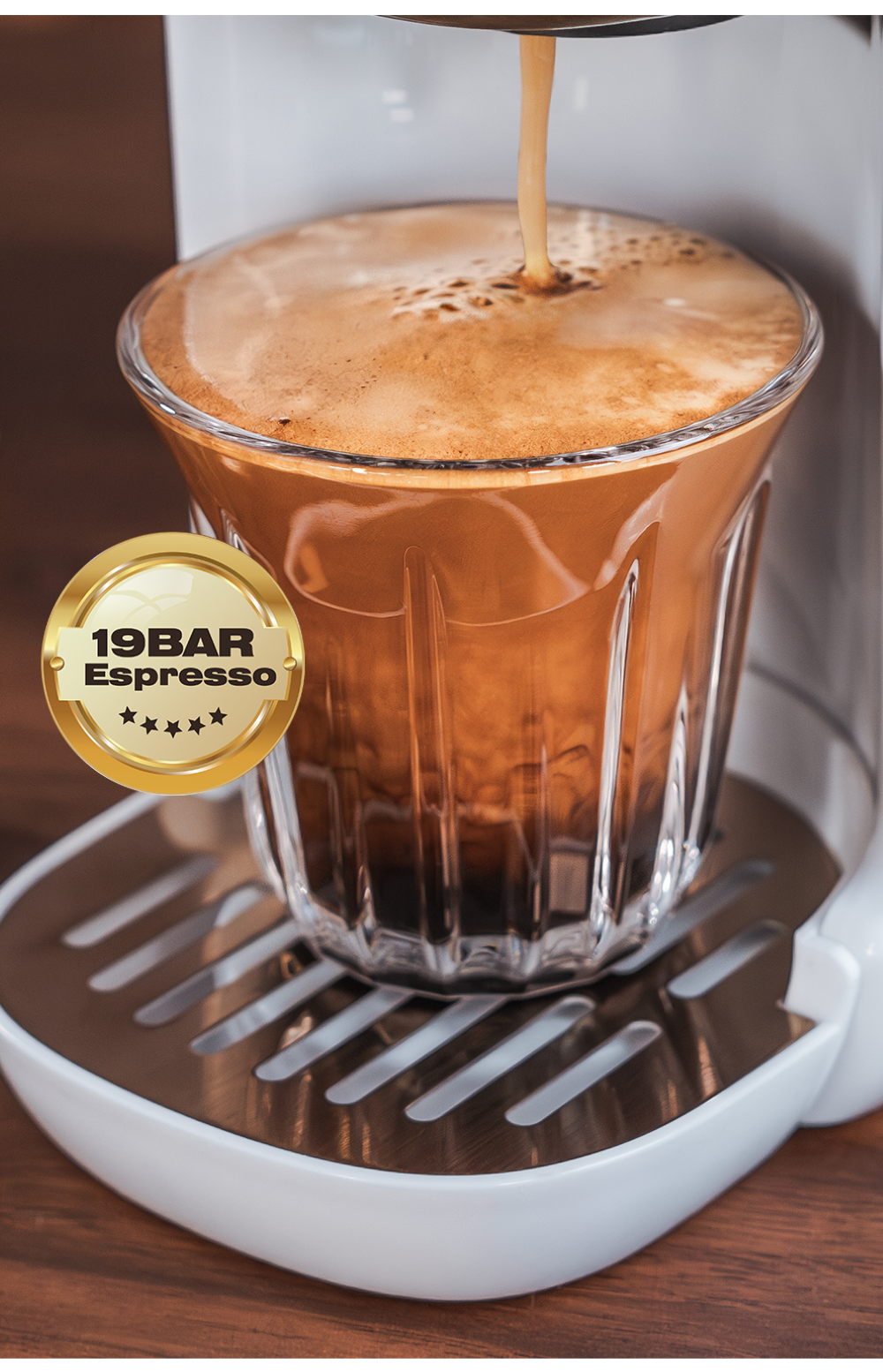Un espresso fresco viene versato in un bicchiere con crema e sigillo d'oro.