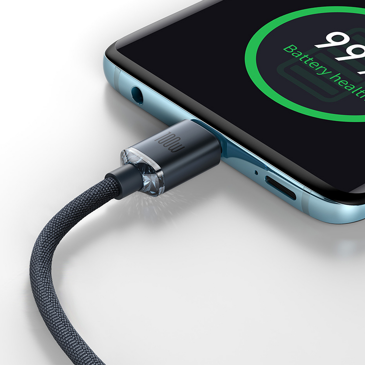 Een zwarte gevlochten 100W USB-C-kabel aangesloten op een blauwe smartphone met 99% batterijstatus op het scherm.