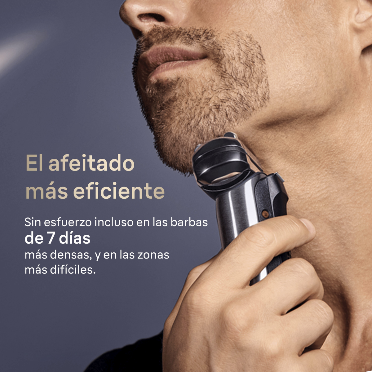 Un uomo si rade la barba usando un rasoio elettrico nero su sfondo grigio.