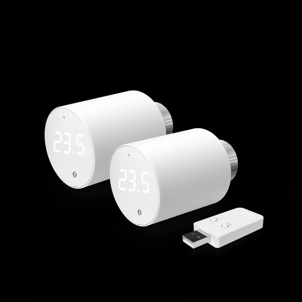 Dos termostatos inteligentes blancos con pantalla digital que muestra 23.5 y un pequeño receptor USB sobre fondo negro.