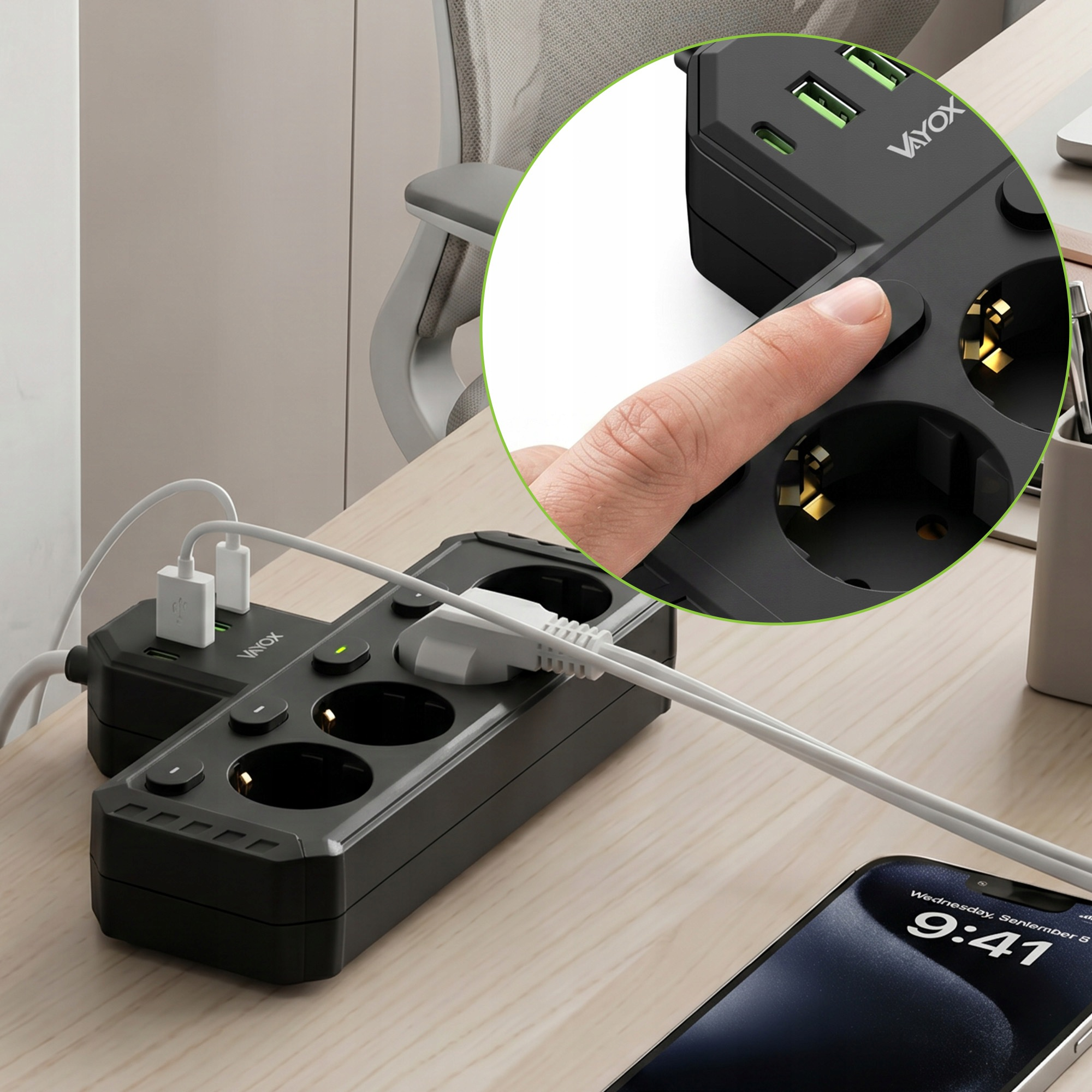 Palec naciska przycisk zasilania na czarnej listwie zasilającej Vayox z portami USB.