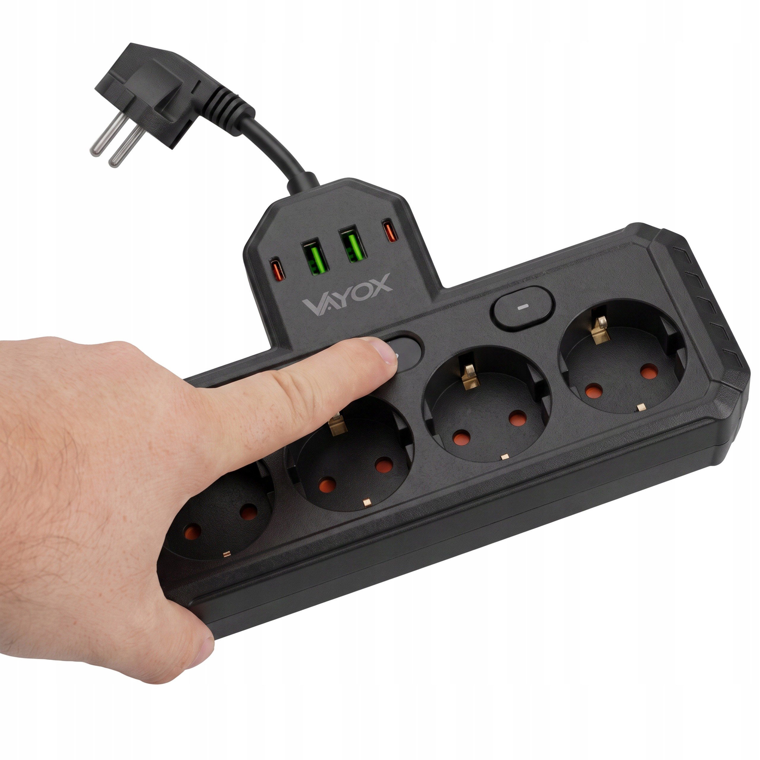 Ręka naciska przycisk zasilania na czarnej listwie zasilającej Vayox z portami USB.