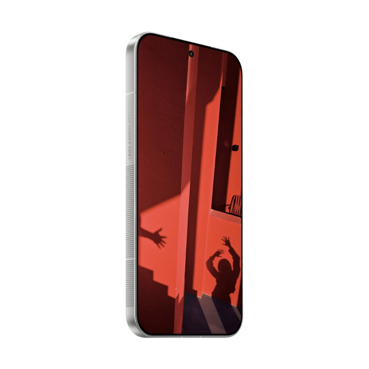 Uno smartphone mostra una parete rossa con le ombre di una persona e di una mano.